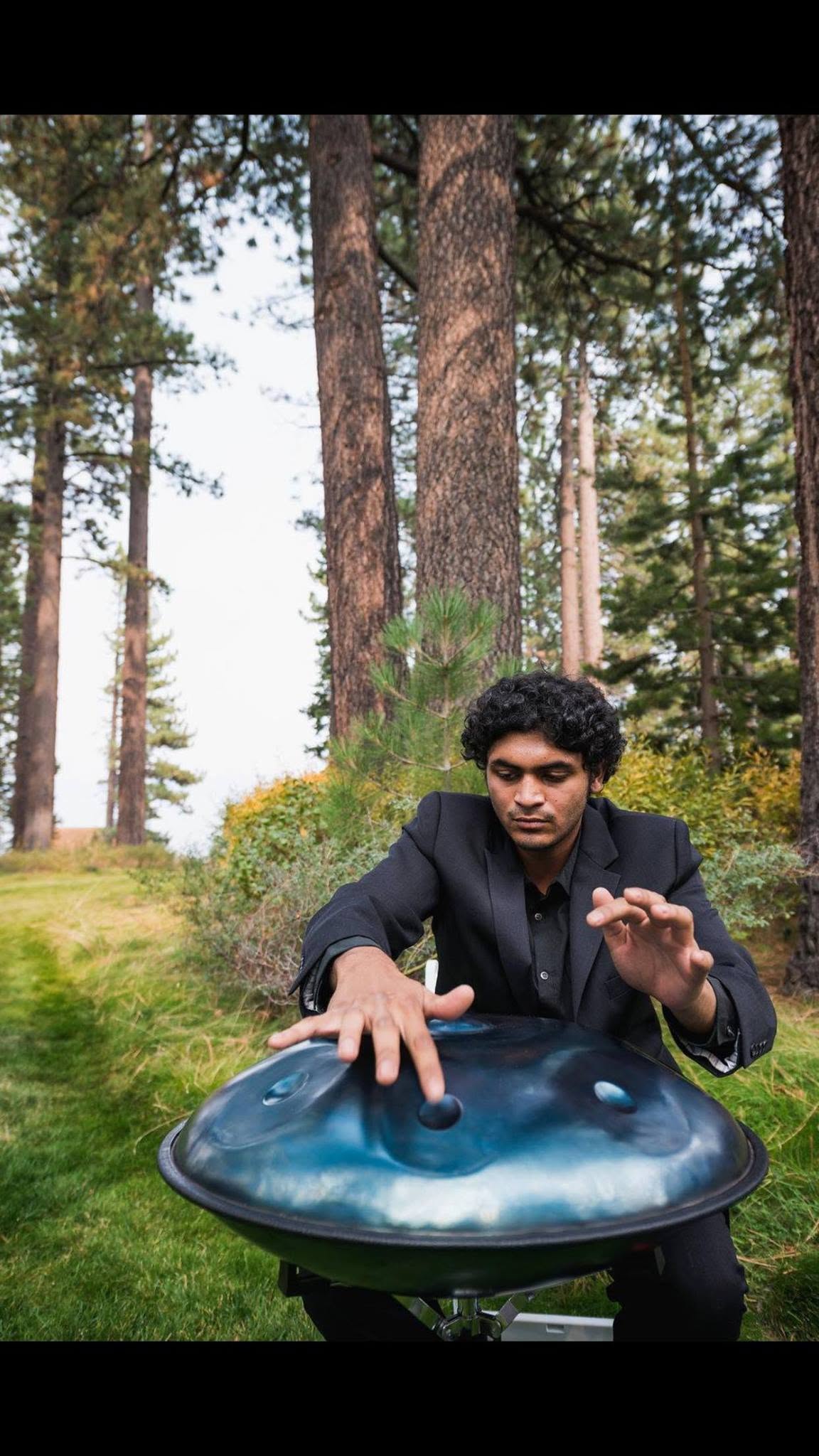 Ash performing on handpan among the pines